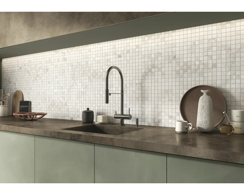 Moderne Küche mit Mosaikfliesenspiegel, dunkler Arbeitsplatte und einer hohen Armatur am Waschbecken.