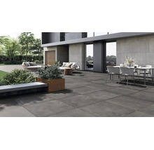 Moderne Terrassenplatte aus Feinsteinzeug auf einer weitläufigen Außenterrasse mit Gartenmöbeln vor einem modernen Wohnhaus.