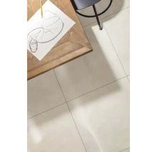 Ein heller Wohnraum mit großformatigen Fliesen auf dem Boden, einem Holztisch mit Zeichnung und einem Stuhl in einer minimalistischen Umgebung.