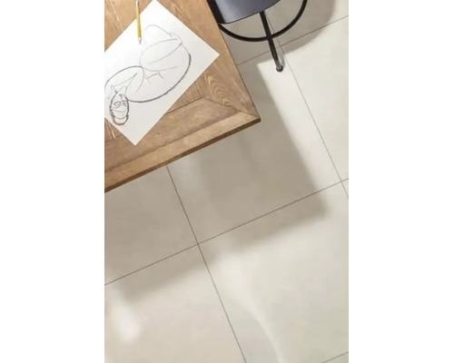 Ein heller Wohnraum mit großformatigen Fliesen auf dem Boden, einem Holztisch mit Zeichnung und einem Stuhl in einer minimalistischen Umgebung.