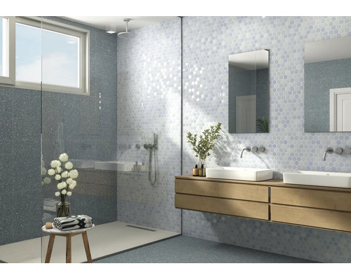 Modernes Badezimmer mit Dusche, Doppelwaschtisch auf einem Holzunterschrank und Wandfliesen in Hexagonoptik sowie Terrazzodesign.