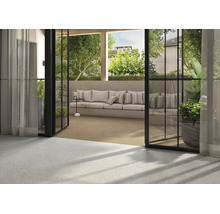 Terrasse mit modernen Terrazzofliesen und offenem Übergang zum Wohnbereich, gemütliche Sitzlounge mit Kissen im Freien.