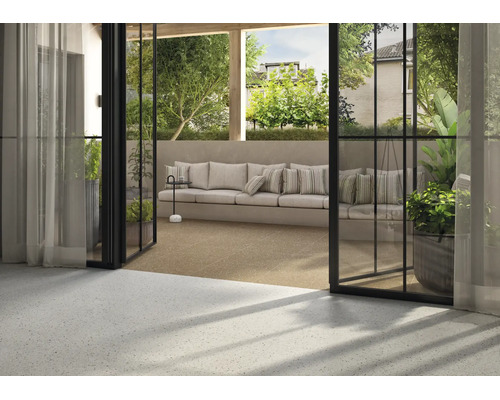 Terrasse mit modernen Terrazzofliesen und offenem Übergang zum Wohnbereich, gemütliche Sitzlounge mit Kissen im Freien.