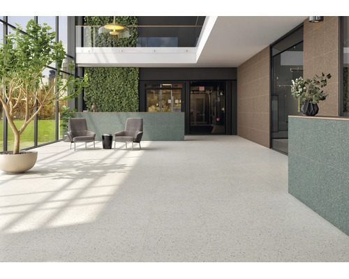 Moderne Eingangshalle mit großformatigen hellen Terrazzofliesen am Boden und strukturierten Wandfliesen in Grün und Braun.