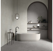 Modernes Badezimmer mit freistehender Badewanne, bodenstehender Armatur, dekorativer Wandnische mit Rundbogen und Regalen sowie stilvoller Leuchte.