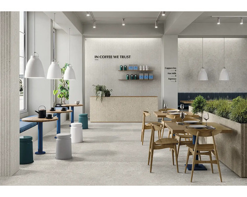 Modernes Café mit Steinfliesen an Wand und Boden, Holztischen, Holzstühlen und hängenden Leuchten in einem hellen, einladenden Innenraum.