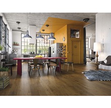 Helles Wohnzimmer mit Holzboden, Esstisch, Stühlen und Küchenbereich im Loftstil
