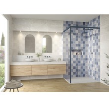 Badezimmer mit Waschtisch, Spiegeln und begehbarer Dusche mit blauen Fliesen.