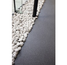 Dekorative weiße Kieselsteine neben grauem Bodenbelag