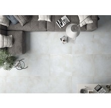 Heller Wohnraum mit Fliesenboden, Sofa, Stehlampe und Tisch