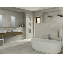 Helles Badezimmer mit grauen Fliesen, Badewanne und Waschtisch mit zwei Waschbecken.