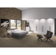 Helles Schlafzimmer mit Bett, Kleiderschrank, Sessel und Dekoration