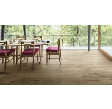 Esszimmer mit Holzboden, Tisch und Stühlen vor Fensterfront mit Blick ins Grüne