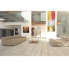 Helles Wohnzimmer mit Sofa, Couchtisch und Kunstwerken an den Wänden