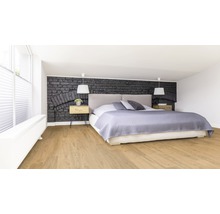 Schlafzimmer mit Bett, Nachttischen und Wand in Steinoptik