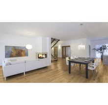 Heller Wohnraum mit Holzboden, Kamin, Sofa und Esstisch