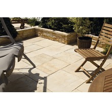 Gartenszene mit Terrassenplatten, Mauer und Gartenmöbeln