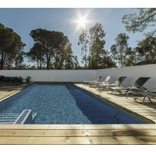 Außenpool mit Holzdeck und Liegestühlen vor Bäumen