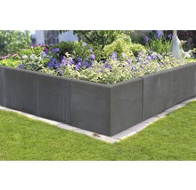 Hochbeet aus Betonsteinen mit Blumen bepflanzt im Garten