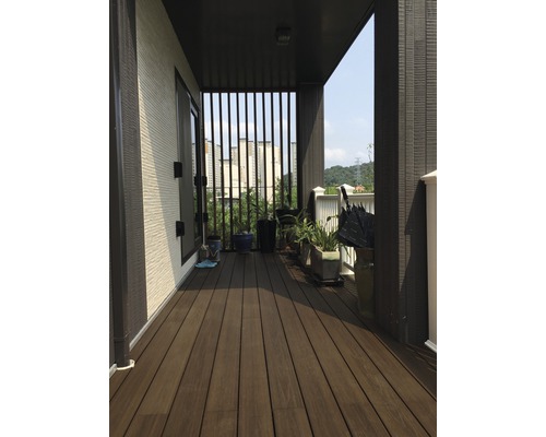 Produktbild 2 (groß) Überdachter Balkon mit Holzterrasse, Pflanzen und Blick auf die Stadt.