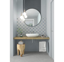 Modernes Badezimmer mit Waschbecken, Spiegel und gemusterten Fliesen.