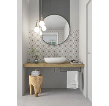 Badezimmer mit Aufsatzwaschbecken, Spiegel, Holzhocker und gemusterten Fliesen