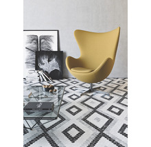 Wohnzimmer mit Sessel, Couchtisch und dekorativem Bodenbelag