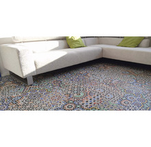 Detailaufnahme eines Zimmers mit einem Sofa und einem Boden mit Musterfliesen