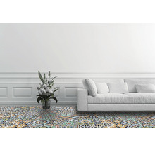 Wohnzimmer mit gemusterten Bodenfliesen, einem Sofa und einer Blumenvase