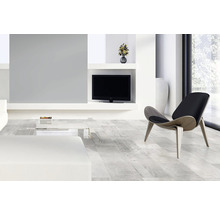 Helles Wohnzimmer mit Design-Sessel, Fernseher und Couch