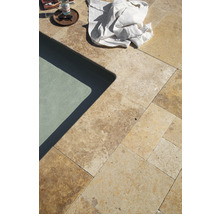 Detailaufnahme von Travertinplatten neben einem Pool mit einem Tuch und Getränken