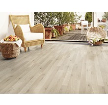 Heller Holzboden mit Korbsessel, Früchten und Blumen auf der Terrasse