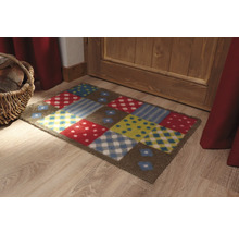 Bunte Fußmatte mit verschiedenen Mustern vor einer Tür.