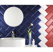 Badezimmer mit Waschbecken, Spiegel und Fliesen im Fischgrätmuster