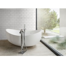 Badezimmer mit freistehender Badewanne, Armatur und Fenster zum Garten