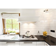 Helle Küche mit Spüle, Kochfeld, Dunstabzugshaube und gefliesten Wänden