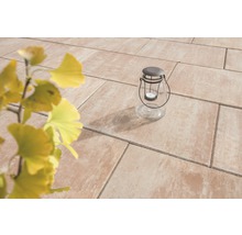 Gartenszene mit Terrassenplatten und Glaslaterne mit Kerze