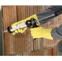 Handwerker verwendet eine Kartuschenpistole an einer Ziegelwand