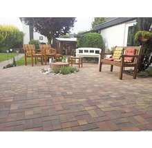 Gartenbereich mit Steinboden, Gartenmöbeln und Bepflanzung