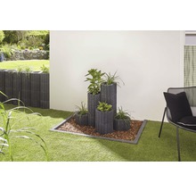 Gestaltungsidee für den Garten mit Pflanzsteinen und Pflanzen auf einer Rasenfläche.