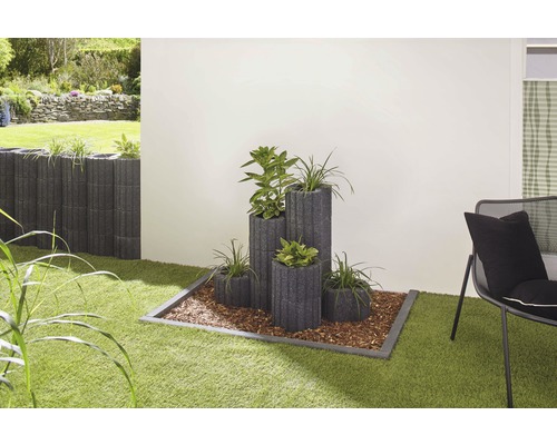 Gestaltungsidee für den Garten mit Pflanzsteinen und Pflanzen auf einer Rasenfläche.