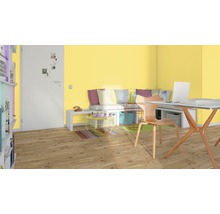 Helles Arbeitszimmer mit Schreibtisch, Stuhl und Sitzgelegenheit vor gelber Wand