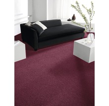 Innenraum mit dunkelrotem Teppichboden, schwarzem Sofa und weißen Möbeln