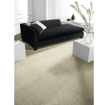 Heller Teppichboden in einem Wohnzimmer mit schwarzem Sofa und weißen Beistelltischen.