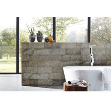 Modernes Badezimmer mit Natursteinwand, freistehender Badewanne und Zimmerpflanzen