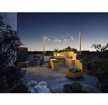 Dachgarten mit Holzmöbeln, Grill und Beleuchtung unter dem Sternenhimmel