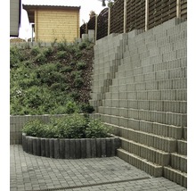Gestufte Gartenmauer aus Betonsteinen mit Bepflanzung