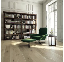 Helles Wohnzimmer mit Bücherregal, Sessel, Hocker und Holzboden