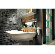 Badezimmer mit Waschbecken, Armatur, Spiegel, Wandverkleidung aus Stein und Glasbausteinen