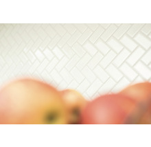 Weiße Fliesenwand im Fischgrätmuster